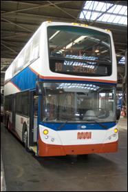 double decker bus in red, white, and blue, with a Muni worm logo